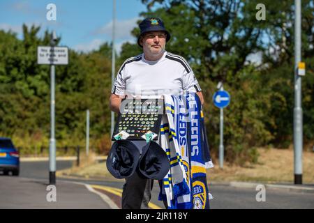 Un homme qui vend des marchandises Leeds United à l'extérieur du stade d'Elland Road en prévision du match de cet après-midi Banque D'Images