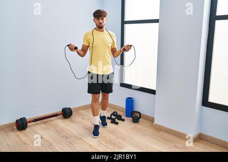 Homme arabe avec la formation de la barbe avec corde de saut sceptique et nerveux, frowning bouleversé à cause du problème. Personne négative. Banque D'Images
