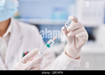 Jeune scientifique tenant un vaccin covid en laboratoire Banque D'Images