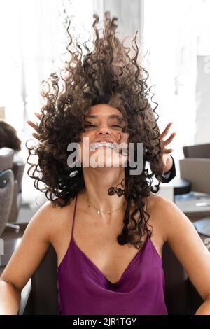 Photo verticale d'une femme qui agite ses cheveux dans un salon de coiffure Banque D'Images