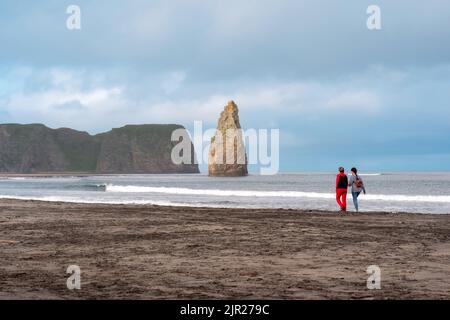 Yuzhno-Kurilsk, Russie - 28 juillet 2022: Les gens marchent le long de la rive de l'océan sur l'île de Kunashir donnant sur les falaises côtières Banque D'Images