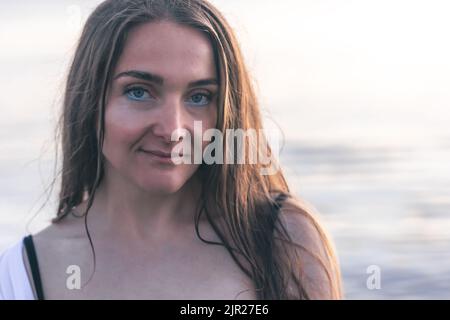 Portrait d'une jeune femme sur un fond flou de la mer. Banque D'Images