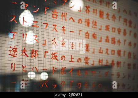 Texte japonais rouge écrit sur un verre dans un restaurant Banque D'Images