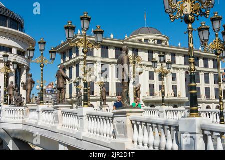 Le pont d'art traversant la rivière Vandar avec le bureau de la police financière et le bâtiment de Ministerie étrangère en arrière-plan. Skopje, Macédoine du Nord. Banque D'Images