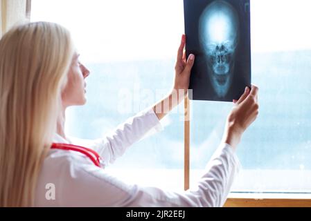 Femme médecin examinant une image radiologique à l'hôpital Banque D'Images