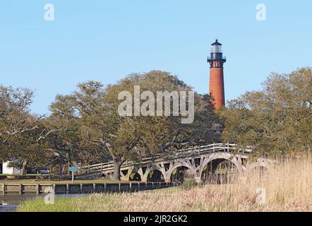 La structure en brique rouge du phare de Currituck Beach s'élève sur un pont en bois au-dessus d'une partie du détroit près de Corolla, en Caroline du Nord Banque D'Images