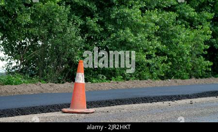 Cône de circulation sur route. Travaux de construction de routes , réparation de routes. Sur la route il y a de l'asphalte frais posé d'un côté de la circulation. Construction et réparation de routes. Photo de haute qualité Banque D'Images