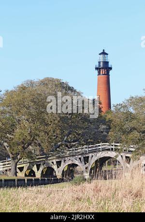 La structure en briques rouges du phare de Currituck Beach s'élève sur un pont en bois au-dessus d'une partie du détroit près de Corolla, en Caroline du Nord Banque D'Images