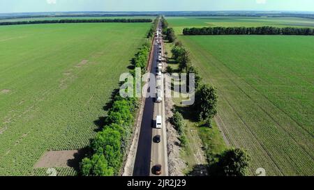 Vue aérienne sur la nouvelle route asphaltée, réparation de la route. Il y a de l'asphalte posé d'un côté de la circulation. En raison de la réparation, le mouvement inverse fonctionne d'un côté de la route,. Photo de haute qualité Banque D'Images