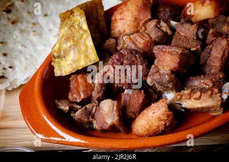 Cuisine latino-américaine de viande frite avec plantain et arepas dans un pot en argile Banque D'Images