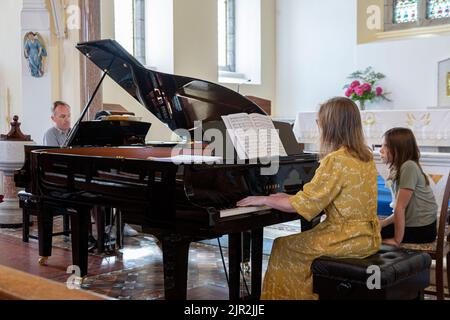 Deux pianistes jouant de grands pianos dans une église Banque D'Images