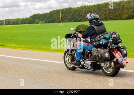 Un automobiliste se déplace le long de la route par une journée ensoleillée en été. Motard sur une moto. Lida, Bélarus - 29 août 2015. Banque D'Images