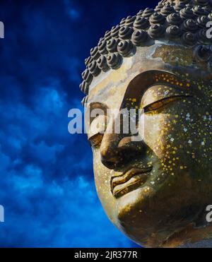 Gros plan de l'image de Bouddha en laiton l'arrière-plan est des nuages bleus. Banque D'Images