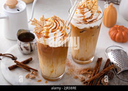 Latte aux épices de citrouille glacée dans de grands verres recouverts de crème fouettée Banque D'Images