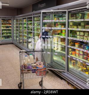 Femme magasiner pour des aliments surgelés dans un supermarché, Royaume-Uni Banque D'Images