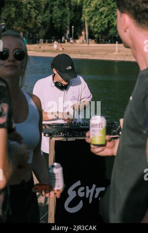 DJ joue un concert et mélange la musique sur une console de platine en plein air dans un parc de Londres. Banque D'Images