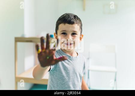 Mignon petit garçon caucasien montrant sa pépinière peinte à la main. Photo de haute qualité Banque D'Images