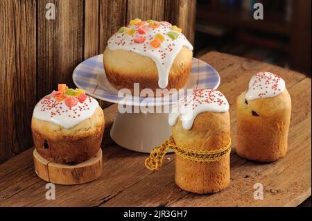 Kulich, pains doux russes de pâques décorés de glace et de fruits confits sur fond de bois horizontal Banque D'Images