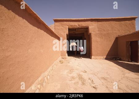 Maison à tinghir, maison traditionnelle d'argile et de paille. Maison de terre avec portes en acier bleu. Une porte ouverte. Banque D'Images