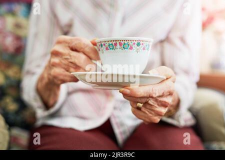 Ce n'est pas un après-midi sans thé de l'après-midi. S femme senior ayant une tasse de thé. Banque D'Images