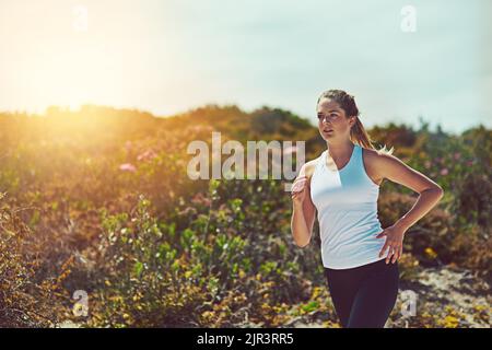 Le corps réalise ce que croit l'esprit. Une jeune femme sportive jogging à l'extérieur. Banque D'Images