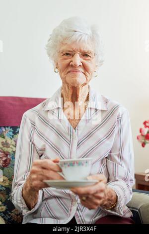 N'importe qui s'occupe de me rejoindre pour un thé. Portrait d'une femme âgée ayant une tasse de thé. Banque D'Images