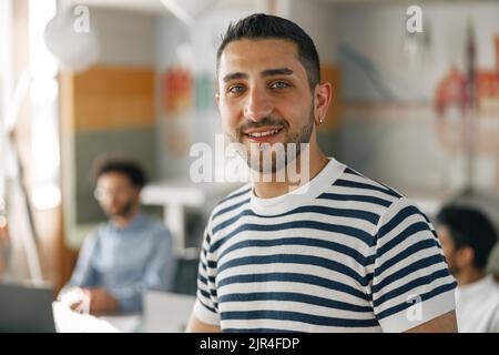 Portrait d'homme d'affaires souriant dans des vêtements décontractés debout dans un bureau moderne Banque D'Images