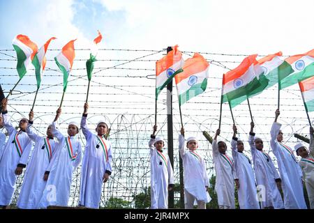 Les enfants participent à un « Tiranga Yatra » organisé par des responsables de la FBS (Border Security Force) dans le cadre des célébrations de « Azadi ka Amrit MahotSAV » pour commémorer le 75th anniversaire de la Journée de l'indépendance de l'Inde le long de l'escrime frontière entre l'Inde et le Bangladesh dans la région de Boxanagar. Agartala. Tripura, Inde. Banque D'Images