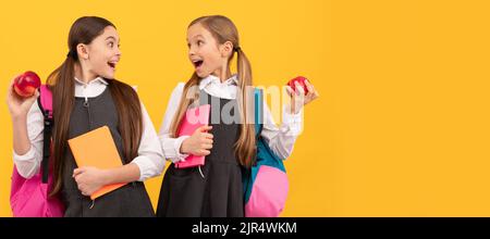 Filles d'école amis. Les enfants surpris tiennent des pommes. . Affiche horizontale isolée de la jeune fille étudiante. Bannière en-tête portrait de la copie de fille d'école Banque D'Images