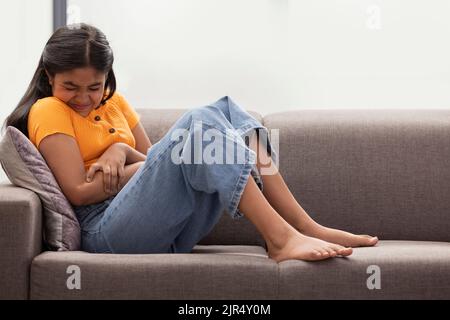 Portrait d'une fille qui pleure sur le canapé à la maison Banque D'Images