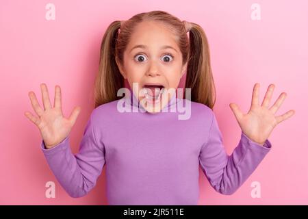 Photo de jeune jolie petite fille mignonne jouant cacher et chercher avec des amis dans la maternelle isolée sur fond de couleur rose Banque D'Images