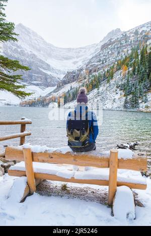 Lake Agnes by Lake Louise le parc national Banff est un lac situé dans les montagnes Rocheuses canadiennes. Un jeune couple de femmes assis sur un banc près du lac pendant une journée froide en automne au Canada Banque D'Images