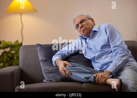 Portrait d'un homme âgé souffrant de douleurs au genou Banque D'Images