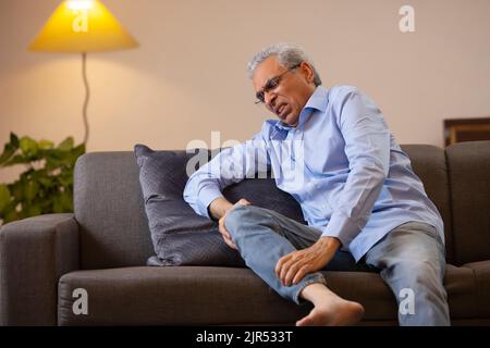 Portrait d'un homme âgé souffrant de douleurs au genou Banque D'Images