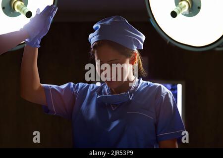 Portrait d'une infirmière féminine heureuse donnant cinq élevé après une chirurgie réussie dans le théâtre d'opération Banque D'Images