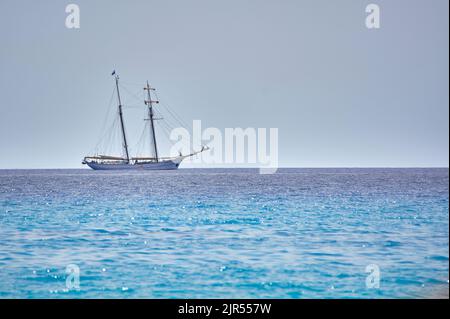 Bateau navigue sur le merveilleux et d'une mer bleue cristalline sur la ligne d'horizon. Banque D'Images