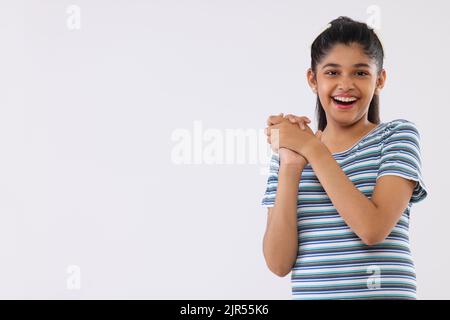 Portrait d'une jeune fille gaie qui fait des gestes sur fond blanc Banque D'Images