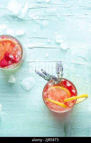 Cocktails d'été frais ou cocktails maison, boissons fraîches aux agrumes et à la lavande, limonade de fête, prise sur fond bleu avec glace Banque D'Images