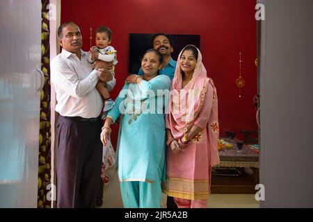 Portrait de membres heureux de la famille indienne debout ensemble à la maison Banque D'Images