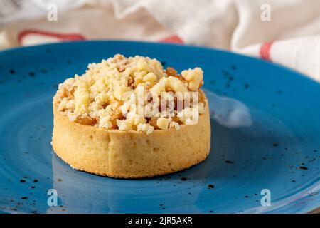 Tarte aux pommes fraîchement cuite en une seule portion sur une assiette en porcelaine bleue Banque D'Images