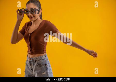 Portrait d'une jeune femme en train de faire la fête avec des lunettes de vue Banque D'Images