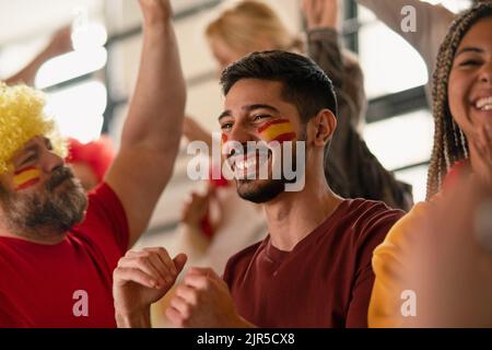 Des fans de football enthousiastes qui ont supplée l'équipe nationale espagnole lors d'un match de football en direct au stade. Banque D'Images