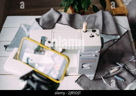 Tournage vidéo du processus de couture, atelier sur la conception de vêtements sur smartphone Banque D'Images