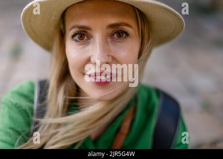 Portrait de jeune femme voyageur, assis, se reposer, souriant et regardant l'appareil photo. Banque D'Images