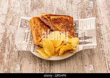 Délicieux sandwich mélangé cuit sur le gril avec du fromage fondu et des chips de pommes de terre Banque D'Images