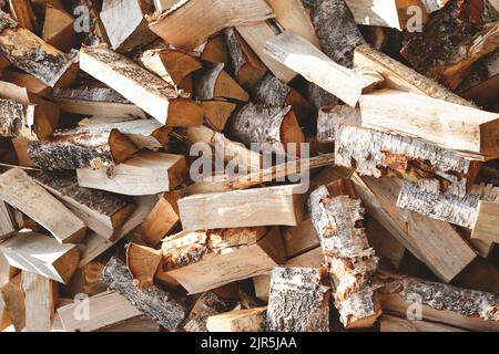 Bois de chauffage de bouleau haché avec une hache. Pile de bois désordonnée, gros plan. Banque D'Images