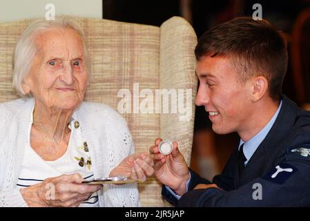 Mme Margaret 'Peggy' Terry, vétéran de la WAAF, âgée de 99 ans, reçoit cinq shillings d'argent en temps de guerre de William Anderson, spécialiste de l'air, classe 1, à Gwernllwyn Care Home, Gorslas, pays de Galles, pour témoigner de l'appréciation de son service lorsque, au cours d'une récente conversation, Elle a mentionné en plaisantant à AS1 Anderson qu'elle devait encore cinq shillings après avoir quitté la RAF, en 1945. Date de la photo: Lundi 22 août 2022. Banque D'Images