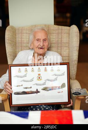 Mme Margaret 'Peggy' Terry, âgée de 99 ans, détient une photo encadrée après avoir reçu cinq shillings d'argent en temps de guerre de William Anderson, spécialiste de l'air, classe 1, à Gwernllwyn Care Home, Gorslas, pays de Galles, pour témoigner de l'appréciation de son service lorsque, au cours d'une récente conversation, Elle a mentionné en plaisantant à AS1 Anderson qu'elle devait encore cinq shillings après avoir quitté la RAF, en 1945. Date de la photo: Lundi 22 août 2022. Banque D'Images