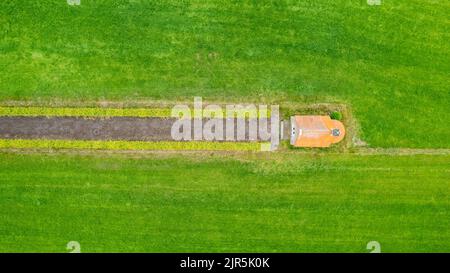 détail du jardin en vue aérienne avec chemin de sable allant entre deux haies vers un petit bâtiment, un hangar ou une chapelle, au milieu. Photo de haute qualité Banque D'Images