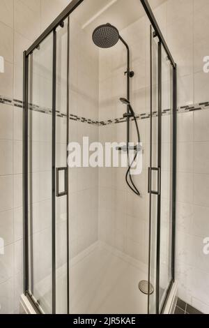 Meuble-lavabo et meuble miroir dans la salle de bains carrelée de blanc avec toilettes accrochées au mur Banque D'Images